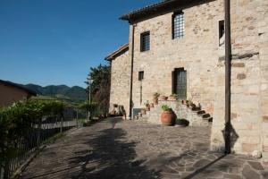 马尔扎博托Tenuta Folesano Wine Estate 13th century的前面有楼梯的石头建筑