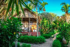 阿姆巴托洛阿卡Coucher de Soleil的花园中树木繁茂的房屋
