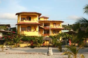 阿塔卡梅斯切洛阿祖尔酒店的棕榈树海滩上一座黄色的大建筑