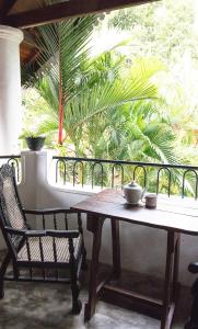 尼甘布维拉塔普洛班住宿加早餐旅馆的棕榈树阳台的桌子和椅子