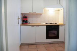 蓬塔阿拉Villa in Punta Ala的厨房配有白色橱柜和黑烤箱。
