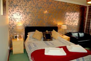 德拉姆纳德罗希特托尔克罗福特旅馆的一间卧室配有一张带两盏灯的床和一张沙发。