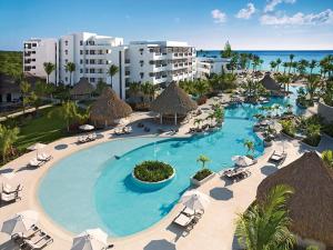 蓬塔卡纳Secrets Cap Cana Resort & Spa - Adults Only - All Inclusive的享有带椅子和遮阳伞的度假村游泳池的空中景致