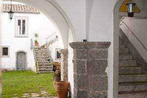 CalvanicoPalazzo D'Orsi的通往白色房屋的拱门,设有楼梯