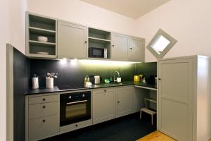 波尔图特征屋公寓的厨房配有白色橱柜和炉灶烤箱。