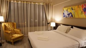 帕府塔拉斯艺术酒店 的配有一张床和一把椅子的酒店客房