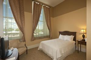 拉斯维加斯历史悠久的广场酒店的一间卧室配有一张床、一把椅子和电视