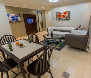 奥朱贝尔Baisan Suites Al Jubail的客厅配有桌椅和沙发