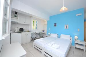 卡塔波拉索非亚阿莫哥斯膳食公寓的卧室配有白色的床和蓝色的墙壁