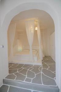 伊奥斯乔拉奥尔加旅馆的白色的客房设有一张带窗帘的床