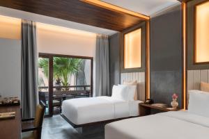 暹粒河流公园贾耶之家度假村的酒店客房设有两张床和用餐区。