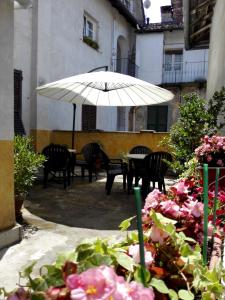 诺维利古雷ViaBasso11 Guest House的庭院配有桌椅和遮阳伞。