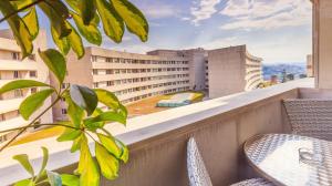 加亚新城Studio Apartment Porto Gaia (Arrabida)的一个带桌椅的阳台和一座建筑