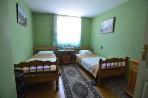 普列夫利亚Hotel 24 jul的一间卧室设有两张床、一个窗户和一个地毯。