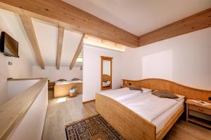 泰塞罗维拉迪博斯科康体酒店的一间带一张大床的卧室,位于一个拥有木制天花板的房间
