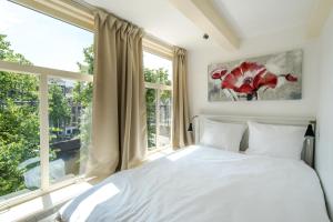阿姆斯特丹蓝色楼梯住宿加早餐旅馆的一间卧室设有一张床和一个大窗户