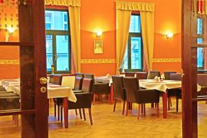 扎泰茨扎泰茨兹莱提列弗酒店的一间带桌椅和橙色墙壁的餐厅