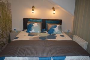 根特莫米住宿加早餐旅馆的一间卧室配有一张带蓝白色枕头的大床