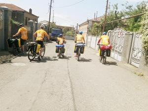 库塔伊西Medico and Suliko Guest House的一群人骑着自行车沿着街道走