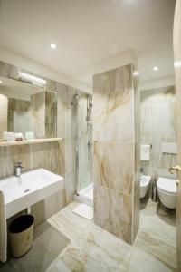 平佐洛Olympic regina hotel的一间带水槽、淋浴和卫生间的浴室