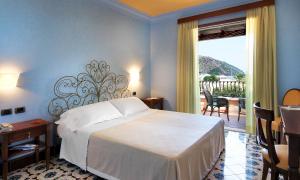 利帕里阿克缇亚酒店的一间带大床的卧室和一个阳台