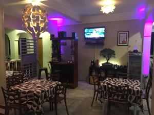 利安星尘海滩酒店的一间设有桌子和电视的用餐室,拥有紫色的灯光