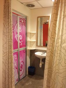 科塔达曼萨拉7星酒店的浴室设有粉红色的门和水槽