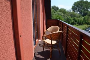 Zlatníky奥鲁姆旅馆的一张柳条椅,坐在带窗户的阳台