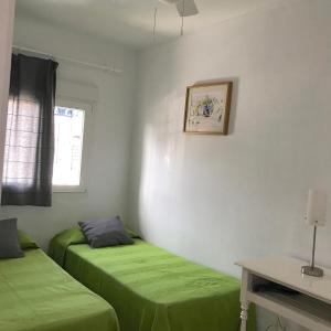 博罗尼亚Sol de Bolonia 8的带窗户的客房内的两张绿色床