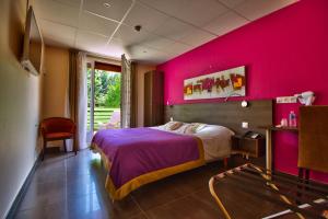 多勒Logis Hôtel Restaurant Le Chalet du Mont Roland的卧室设有粉红色的墙壁、一张床和一把椅子