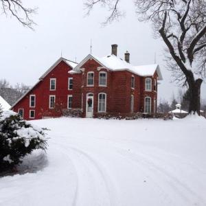 MuscatineStrawberry Farm B and B的一座大红砖房子,有雪