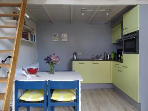 洛赫姆De Akelei的厨房配有黄色和蓝色橱柜和厨房岛