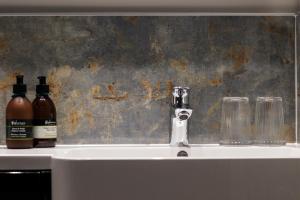克雷格纽尔Pennygate Lodge的浴室水槽上放有2瓶和玻璃杯
