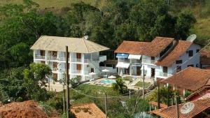 康赛瓦托利亚Pousada Pedacinho do Céu的享有带游泳池的房屋的空中景致