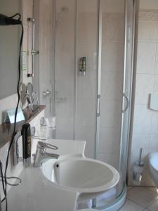诺登诺登公寓式酒店的带淋浴和盥洗盆的白色浴室