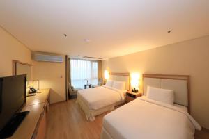 济州市济州岛海洋套房酒店的酒店客房设有两张床和一台平面电视。