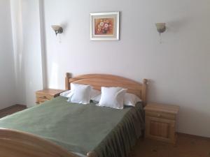 布什泰尼Vila Piano的一间卧室配有带绿色床单和白色枕头的床