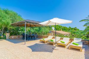 索塔Cas Conco的庭院配有椅子、遮阳伞和桌子。