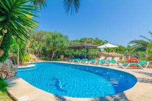 索塔Cas Conco的度假村的游泳池配有椅子和遮阳伞