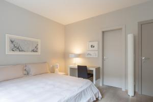 卢森堡四星级公寓式酒店的白色卧室配有床和书桌
