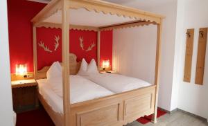 海利根布卢特豪艾斯伯格酒店的卧室配有带白色床单的天蓬床