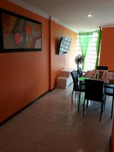 圣玛尔塔Apartamento Perla del Caribe的一间拥有橙色墙壁和桌椅的用餐室