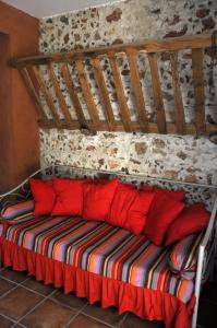 CamélasMas la Mouillere的一张带红色枕头的床