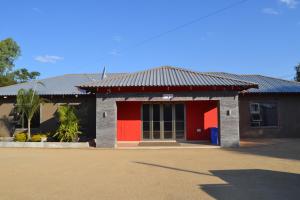 弗朗西斯敦La Signature Guest house的红色和黑色的建筑,有红色的门
