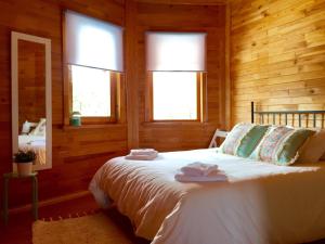 贝尼卡洛Casita de madera的一间卧室配有一张床,上面有两条毛巾