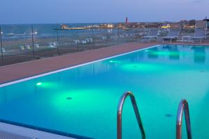 卡奥莱摩纳哥酒店的游泳池,晚上可欣赏到海景