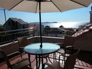 巴斯夸斯巴斯夸斯卡普里舒酒店的阳台配有桌椅和遮阳伞
