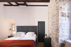 希贝尼克地中海豪华客房旅馆的一间卧室设有两张床和砖墙