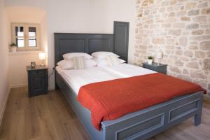 希贝尼克地中海豪华客房旅馆的一间卧室设有一张带砖墙的大床