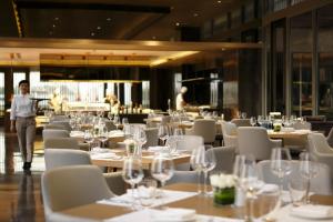 新德里新德里玫瑰色之屋酒店的一间设有白色桌子和白色椅子的餐厅,以及一间供个人用餐的餐厅